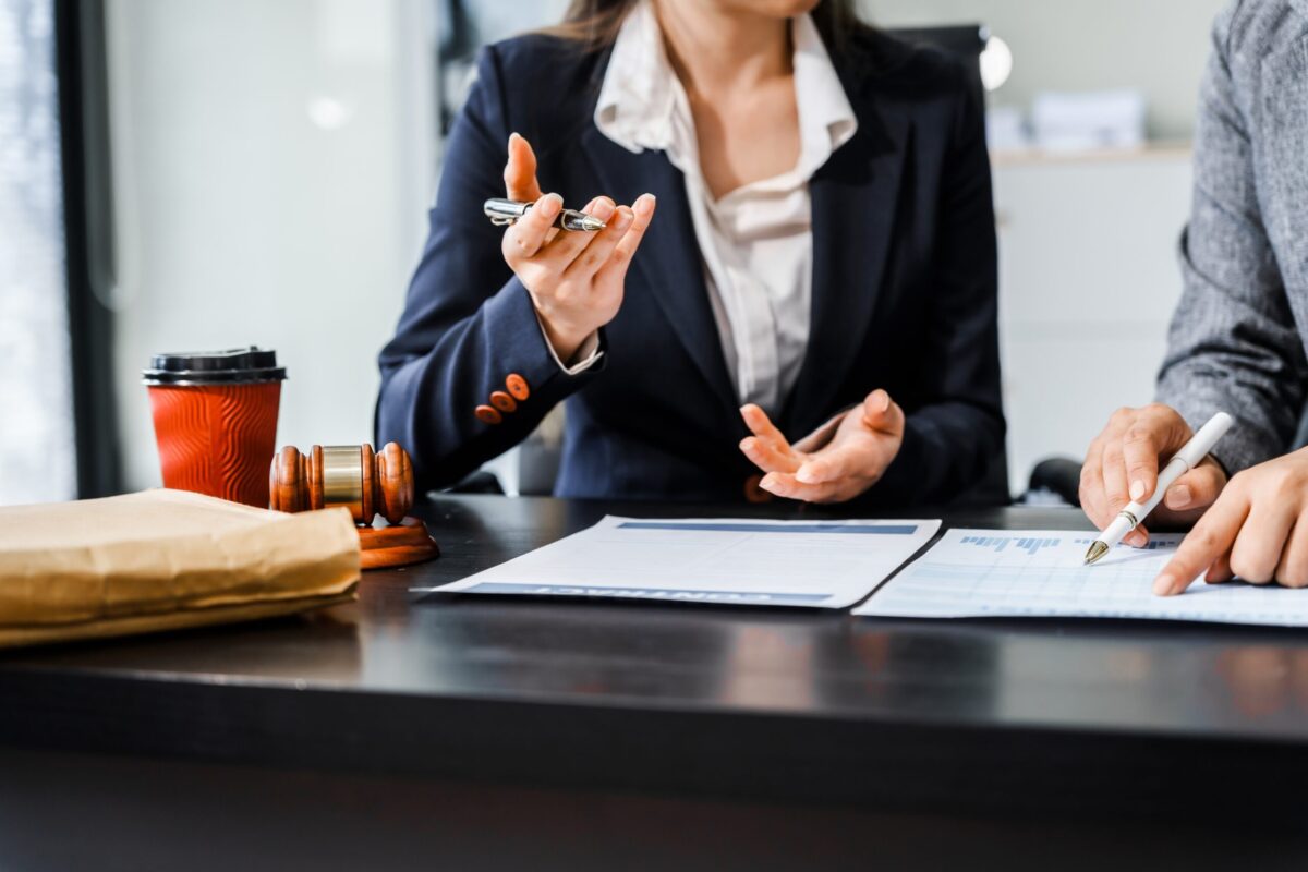 Lawyer and client in business meeting. Coffee cup, papers, on table.
